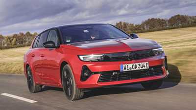 Vauxhall Astra Sports Tourer Electric (2023) review: front three quarter driving, British country lane, low angle, red paint